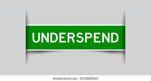 Inserted green color label sticker with word underspend on gray background