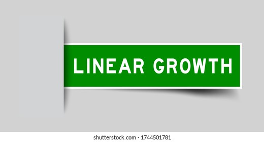 Inserted green color sticker label with word linear growth on gray background