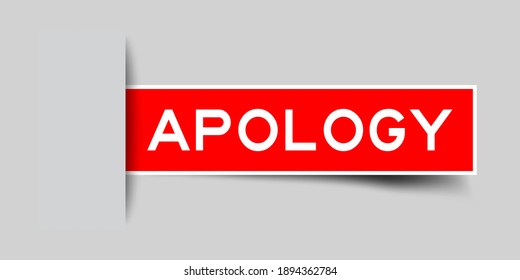 Inserted red color label sticker with word apology on gray background