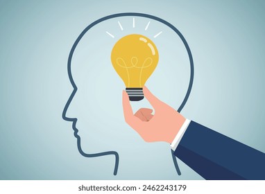 Inspiration concept.Hand holding luminous light bulb, putting in human brain.