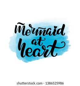 Inspirational handwritten brush lettering mermaid at heart. Vector calligraphy illustration with blue watercolor stain on background. Typography for banners, badges, postcard, t-shirt, prints.
