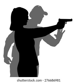 Instructor assisting woman aiming hand gun at firing range