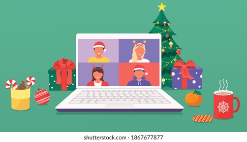 Interior of Christmas and New Years home workplace with christmas tree and decorations, gifts, cane cookies and sweets, coffee, laptop. Colleagues talk to each other on a laptop screen via video call.