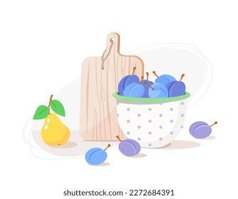 Interior kitchen utensils in country house: plums in enamelled bowl, wooden cutting board, handful of plums and  yellow pear on kitchen table. Concept of healthy eating, vitamins and cooking at home.