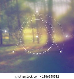 Interlocking circles, triangles and spirals hipster sacred geometry illustration with golden ratio digits and light dots in front of photographic background.