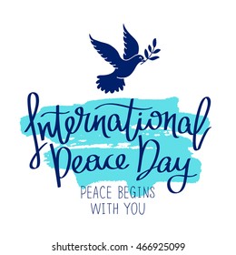 International Day of Peace. Peace begins with you. Trend calligraphy. Vector illustration on white background with a smear of ink blue. Dove with a palm branch. Excellent gift holiday card.