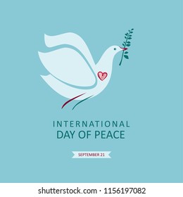 International Day of Peace. Dove with an olive branch in its beak against the sky.