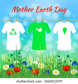 International Mother Earth Day. Concept of the event. T-shirts with eco-signs hang on the rope. Against the background of the sky and wild grass and flowers