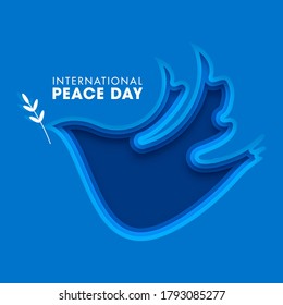 International Peace Day Text on Blue Paper Layer Cut Dove Bird Shape Background.