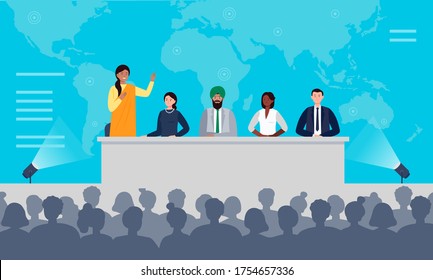 International Press Conference Concept. A Multiethnic Group Of People Is Sitting At The Desk On Stage. An Indian Woman Has A Speech To The Audience. Flat Vector Illustration.