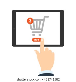 Internet shopping concept. Hand pulling buy button on tablet. Three items in shopping cart. E-commerce concept. Shopping online.