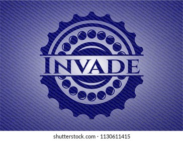 Invade badge with denim background