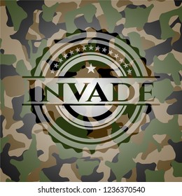 Invade written on a camouflage texture