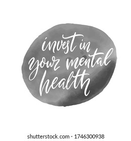 Invest in your mental health. Motivational quote, handwritten calligraphy on gray ink stain