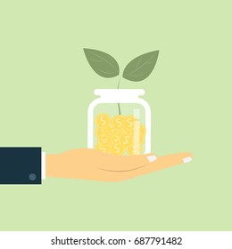 Investment growth concept, hands holding golden coin stack and small tree on green background.