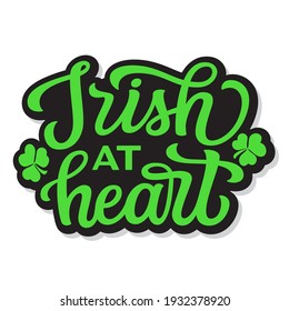 Irish at heart. Hand lettering quote with clover isolated on white background. Vector typography for St. Patrick's day decor, t shirts, posters, cards, banners