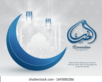 Islamic Holy Month of Ramadan Mubarak with Arabic Calligraphic Text, Blue Crescent Moon, Hanging Lanterns on White Paper Mosque on Silver Background.