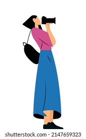 Isolated character photographer. The girl holds a camera in her hands and takes pictures. Flat cartoon illustration.