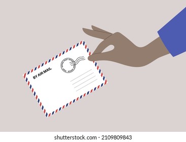 An isolated hand holding an air mail envelope, post office service