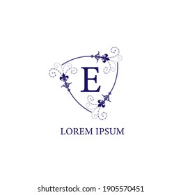 An Isolated on white background decorative floral shield with Lily Flower ornament. Letter E alphabet initial logo design template. Purple Violet Color Theme.