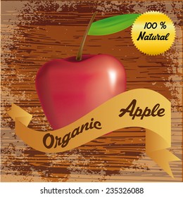 an isolated red apple and a ribbon with text on a wooden background