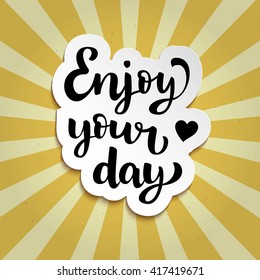 Isolated sticker with hand drawn ink lettering "Enjoy your day" on vintage background with retro sunburst. Vector calligraphy design for banners, posters, coffee menu, motivation, advertising.