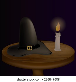 an isolated wooden table with a black hat and a candle with fire