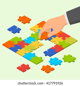 Isometric Colorful Jigsaw Puzzle And Hand Holding One Piece Of Puzzle Over It