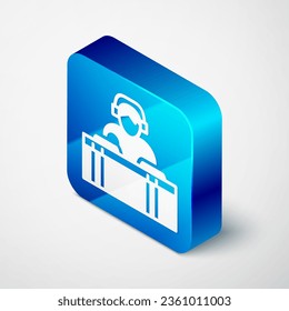 Isometric DJ wearing headphones in front of record decks icon isolated on grey background. DJ playing music. Blue square button. Vector
