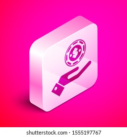 Isometric Hand holding casino chips icon isolated on pink background. Casino gambling. Silver square button. Vector Illustration