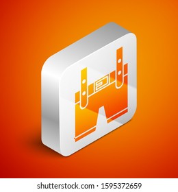 Isometric Lederhosen icon isolated on orange background. Traditional bavarian clothing. Oktoberfest outfit. Pants with suspenders. Patrick day. Silver square button. Vector Illustration