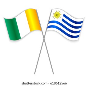 Ivorian and Uruguayan crossed flags. Ivory Coast combined with Uruguay isolated on white. Language learning, international business or travel concept.