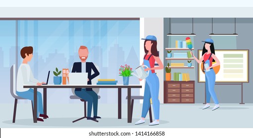 janitors team cleaners in uniform working together cleaning service concept creative co-working center modern office interior flat full length horizontal