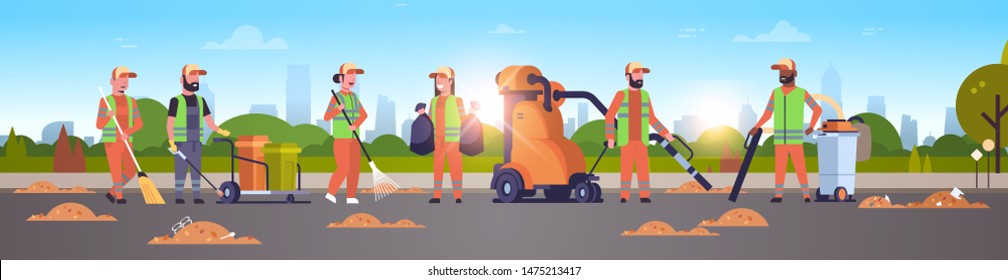 janitors team gathering trash cleaners using vacuum cleaner rack and broom streets cleaning service concept mix race people working together cityscape sunset background full length horizontal