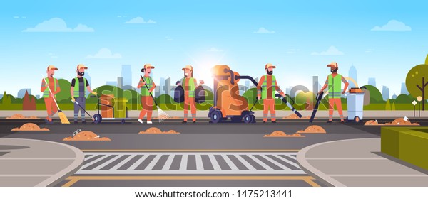 janitors team gathering trash on road cleaners\
using vacuum cleaner rack broom streets cleaning service concept\
mix race people working together cityscape sunset background full\
length horizontal