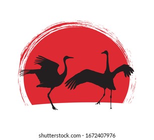 Japanese cranes in dance. Silhouette on sunset background.