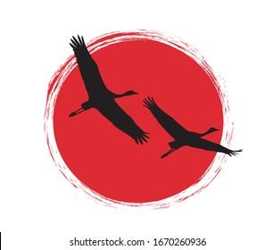 Japanese cranes in flight. Silhouette on sunset background.