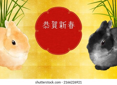 Japanese New Year card for the year of the Rabbit 2023, two rabbits sitting in the shade of grass and gold foil background - Translation: Happy New Year