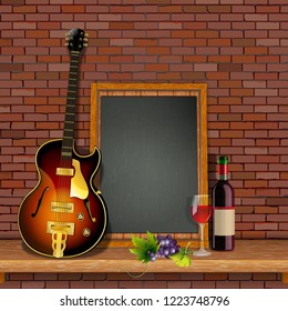 Jazz guitar on the shelf with a brick wall, a bottle of wine and a glass against the background of an empty black board. Template for music or restaurant menu.