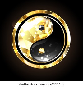 Jewelry, gold and black yin yang symbol on black background.