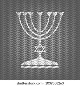 Jewish Menorah candlestick in black silhouette. Vector. White knitted icon on gray knitted background. Isolated.