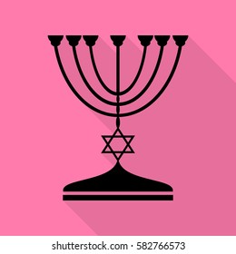 Jewish Menorah candlestick in black silhouette. Black icon with flat style shadow path on pink background.