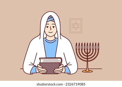 Jewish woman rabbi holds torah in hands and sits near image of star of david, dressed in religious clothes and white veil. Smiling girl learning jewish religion and prayers to worship god