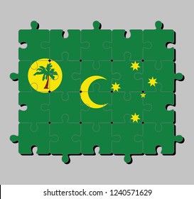 Jigsaw puzzle of Cocos (Keeling) Islands flag in a palm tree on a gold disc, crescent and southern cross on green. Concept of Fulfillment or perfection.