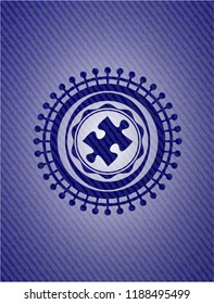 jigsaw puzzle piece icon inside badge with denim texture