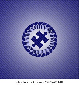 jigsaw puzzle piece icon inside emblem with denim texture