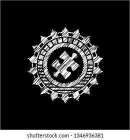 jigsaw puzzle piece icon inside chalk emblem written on a blackboard