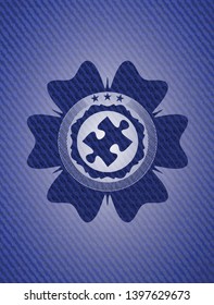 jigsaw puzzle piece icon inside badge with denim texture
