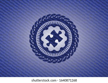 jigsaw puzzle piece icon inside emblem with denim texture