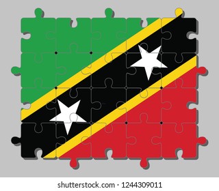 Jigsaw puzzle of Saint Kitts and Nevis flag in yellow edged black diagonal with star, triangle green and red. Concept of Fulfillment or perfection.